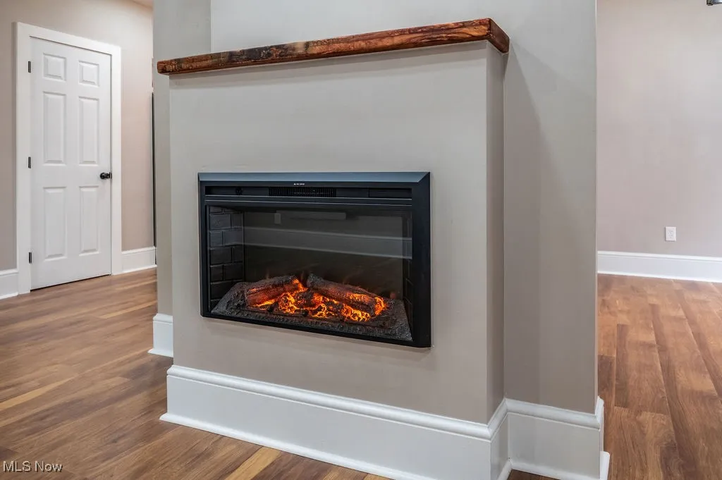 Detailed view of wood finished floors and a glass covered fireplace