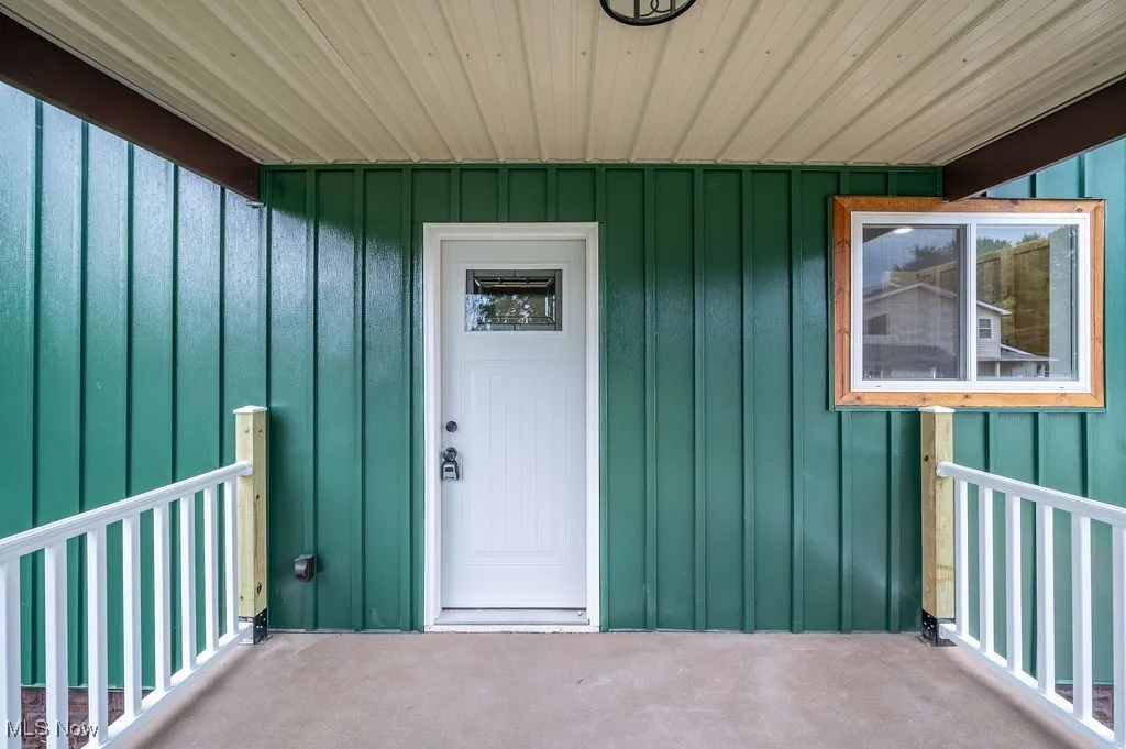 Property entrance featuring board and batten siding and covered porch