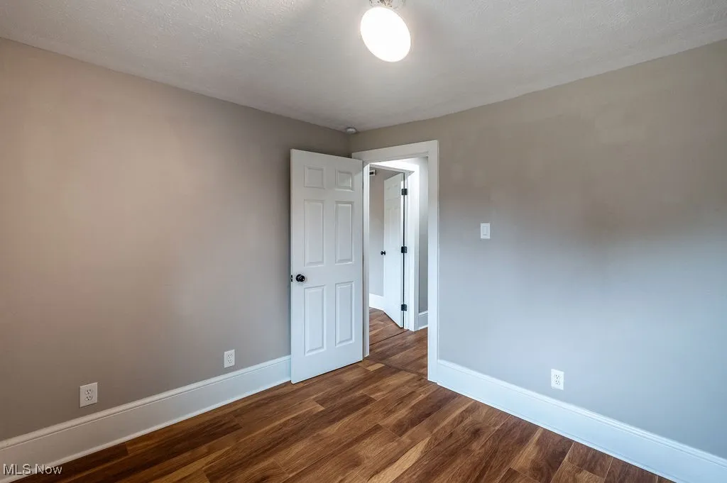 Spare room with dark wood finished floors and a textured ceiling