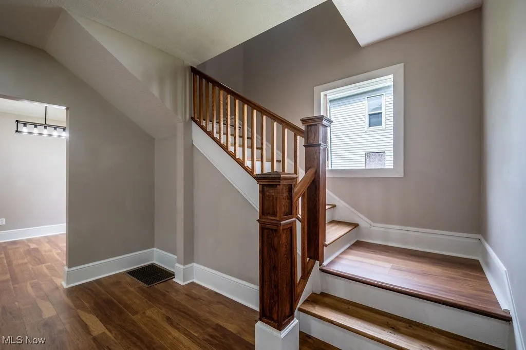 Stairway with wood finished floors and baseboards