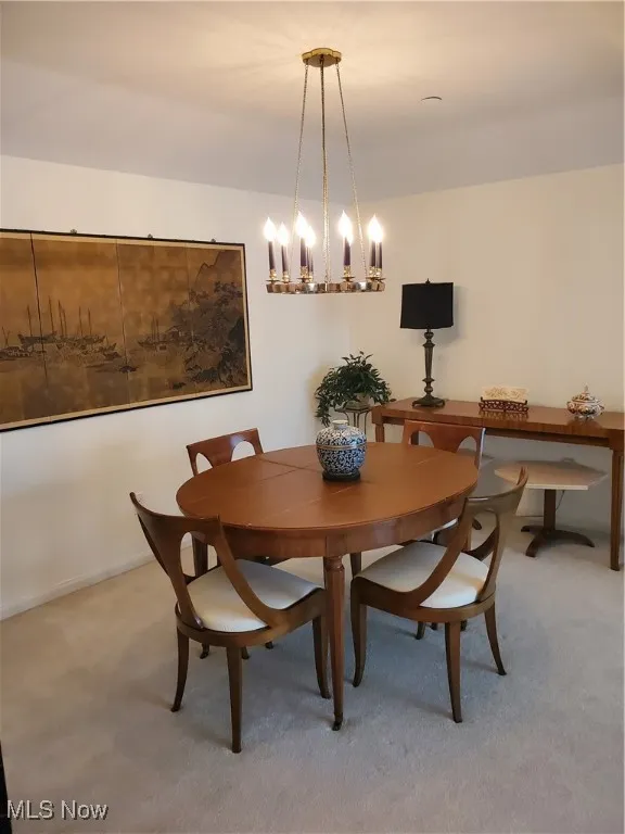 Dining area with carpet flooring and a chandelier