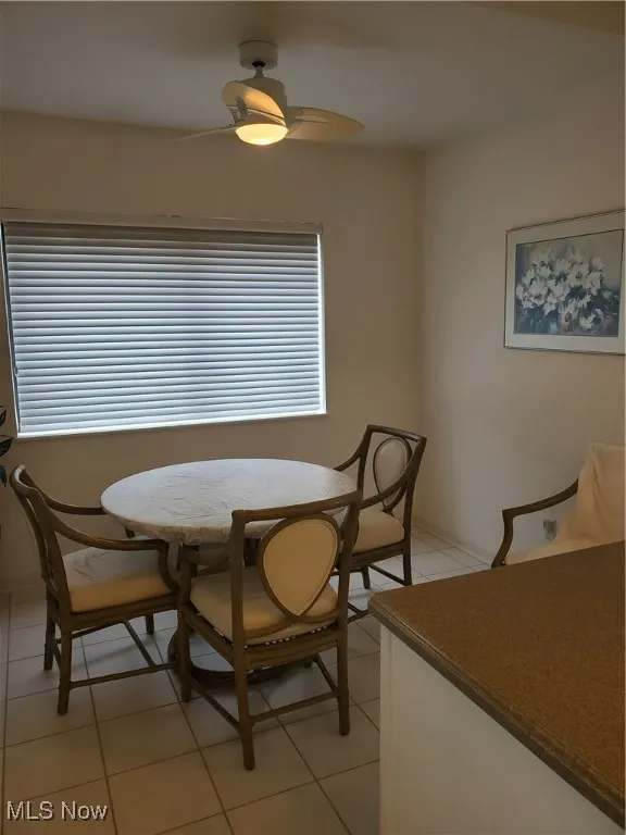 Dining area with light tile patterned flooring and a ceiling fan