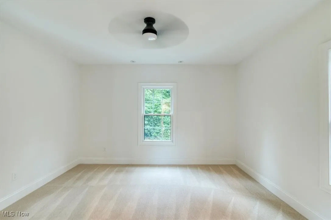 Bedroom with light carpet and a ceiling fan