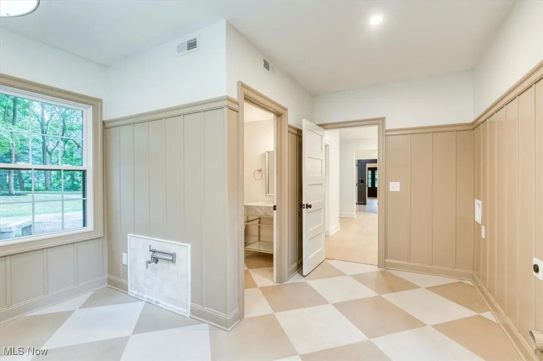Laundry featuring light floors and a dog pot-filler
