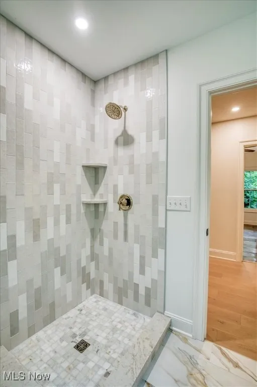Bathroom featuring a stall shower, recessed lighting, and wood finished floors