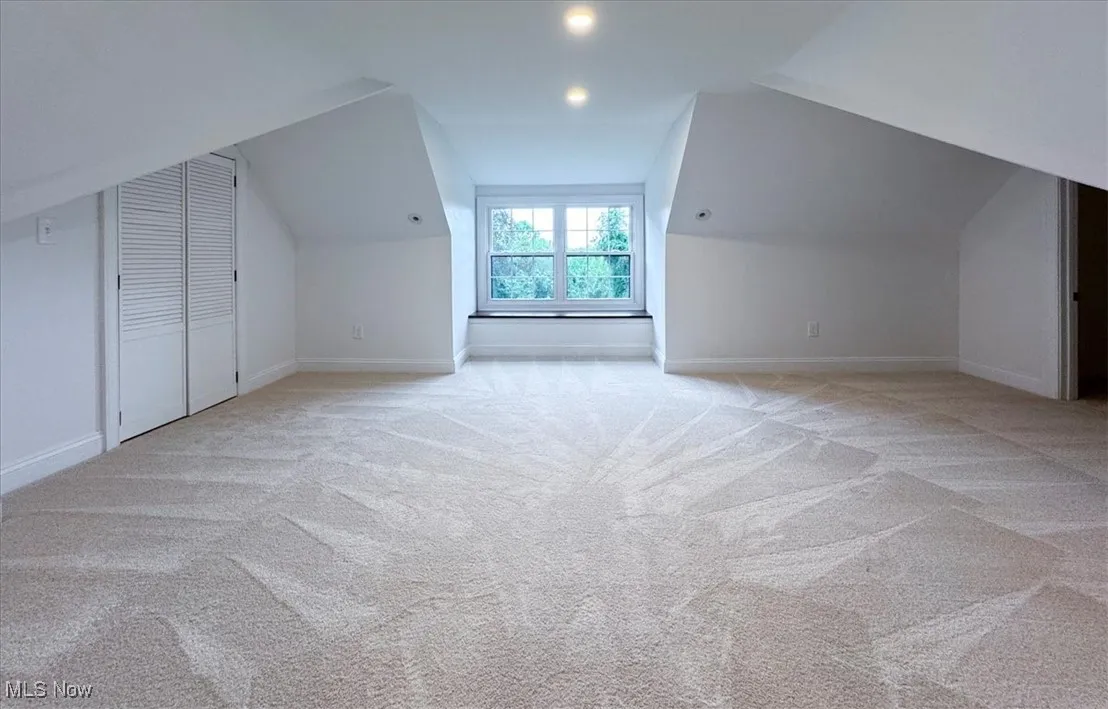 Additional living space with vaulted ceiling, light carpet, and recessed lighting