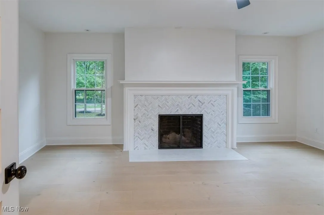 Bedroom with a tiled fireplace and light wood finished floors