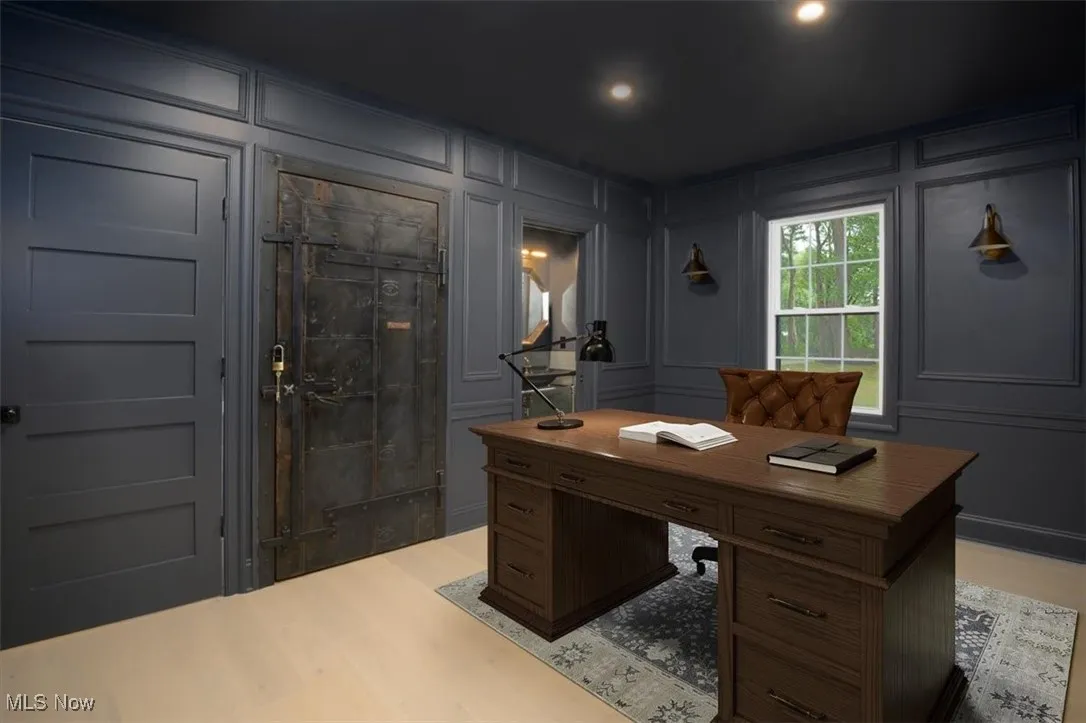 Office space featuring a decorative wall and light wood-style flooring
