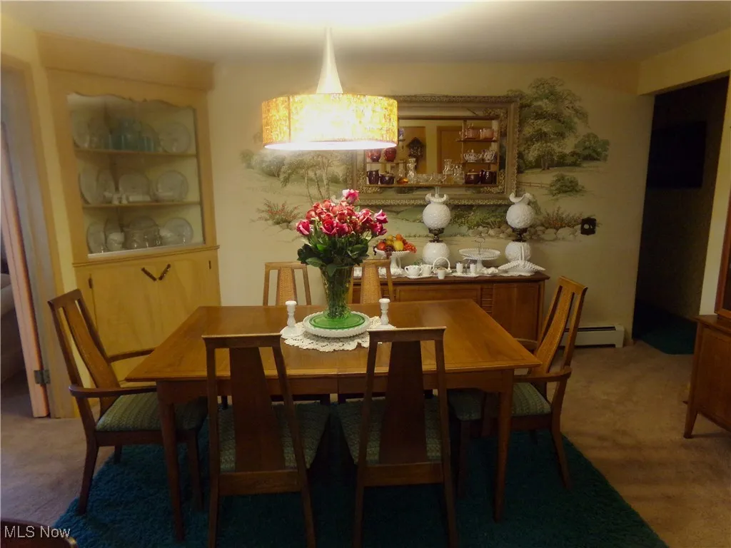 Dining space featuring carpet and baseboard heating