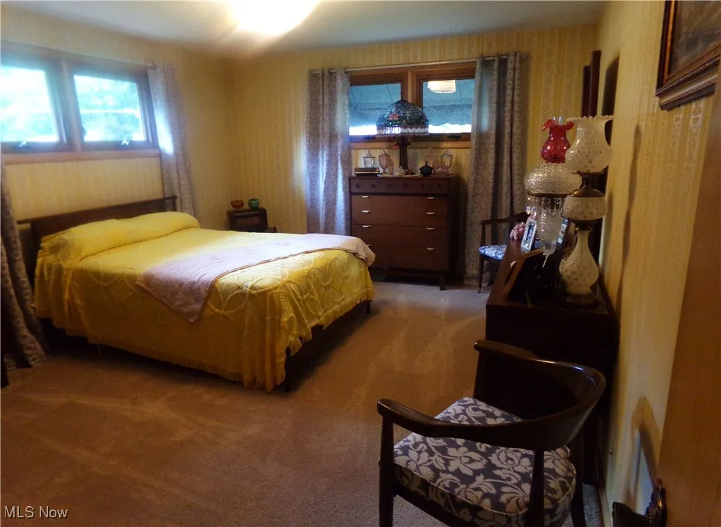 Carpeted bedroom with wallpapered walls