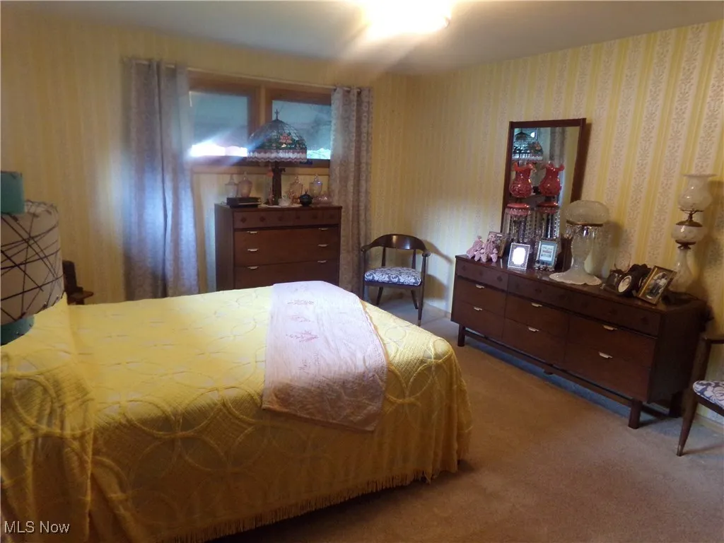 Bedroom featuring carpet flooring and wallpapered walls