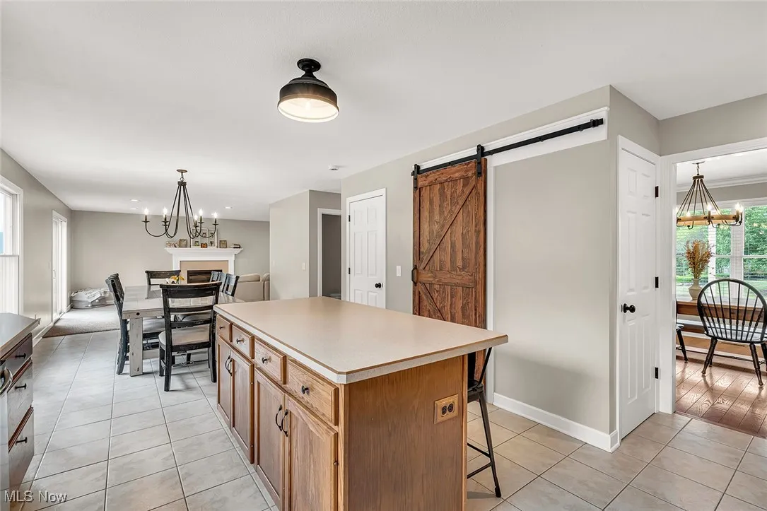 Kitchen featuring a chandelier, hanging light fixtures, a kitchen island, and light tile patterned flooring