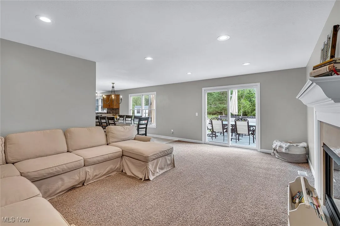 Living room featuring a fireplace with flush hearth, carpet floors, and recessed lighting