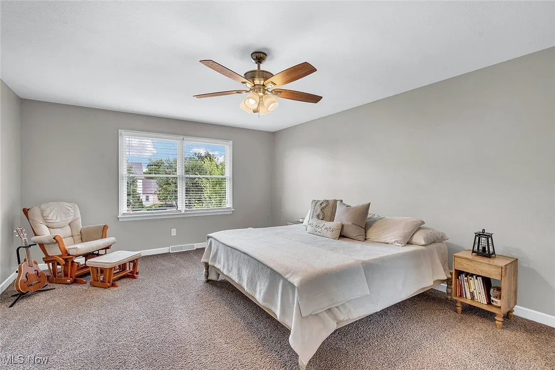Carpeted bedroom featuring baseboards and a ceiling fan