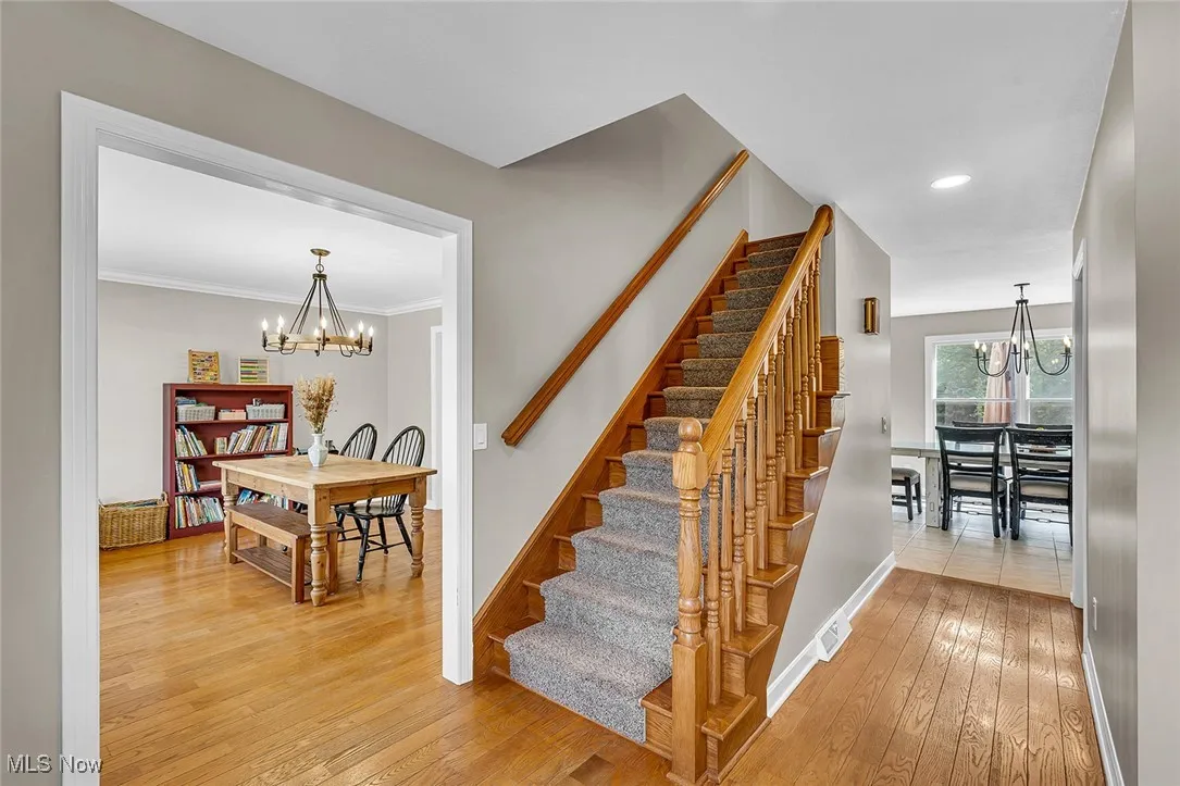 Staircase featuring a chandelier, wood-type flooring, and recessed lighting