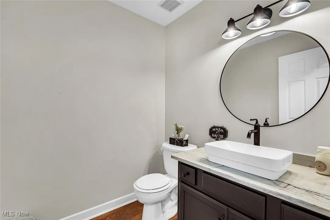Half bath featuring vanity and wood finished floors