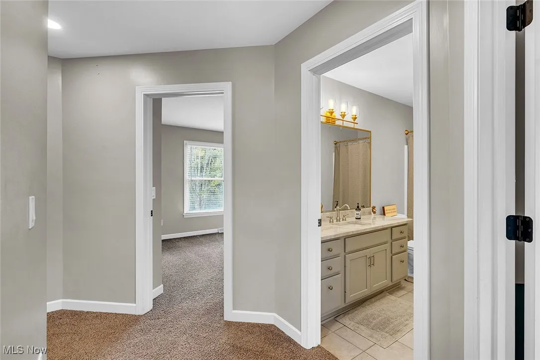 Bathroom featuring vanity, a shower with shower curtain, and light tile patterned flooring