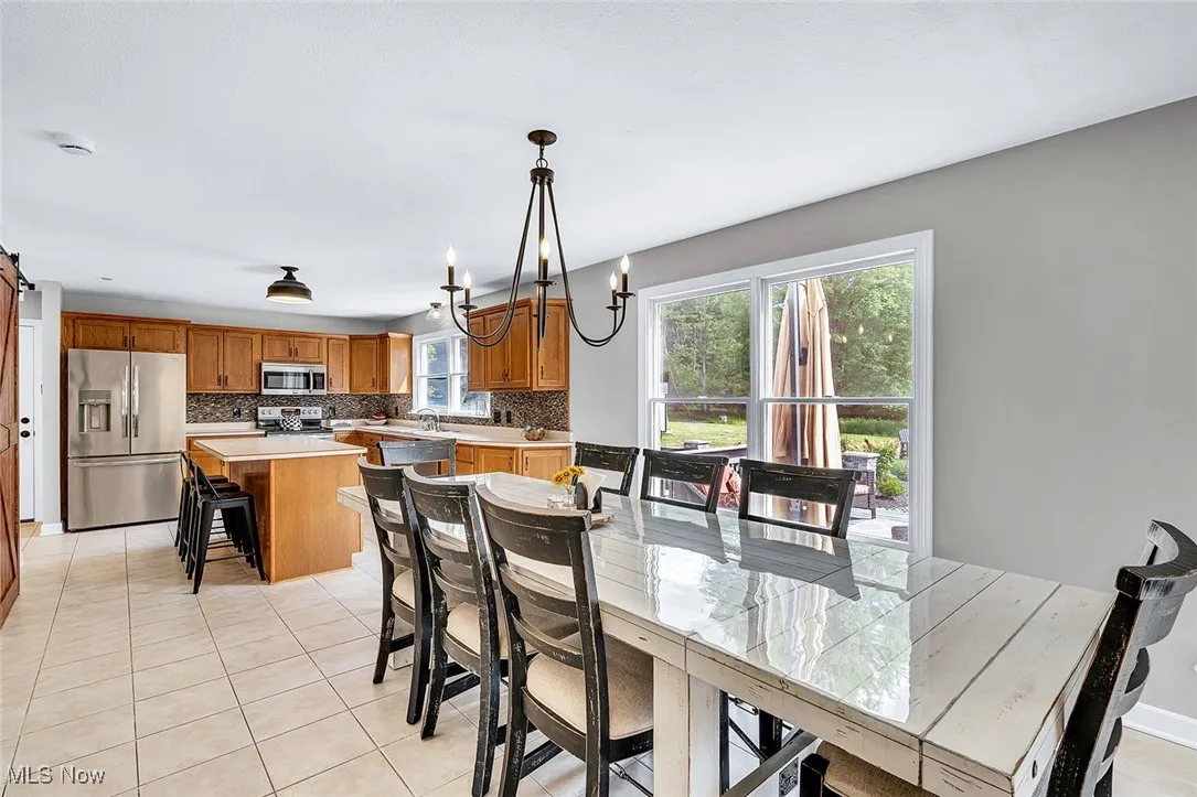 Dining area featuring light tile patterned flooring and a chandelier