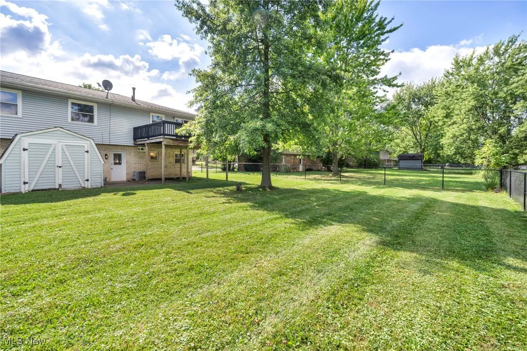 Fenced backyard with a storage shed and private decks for each unit