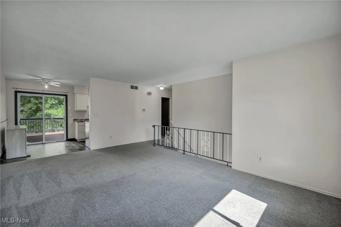 Carpeted living room with view of eat-in kitchen