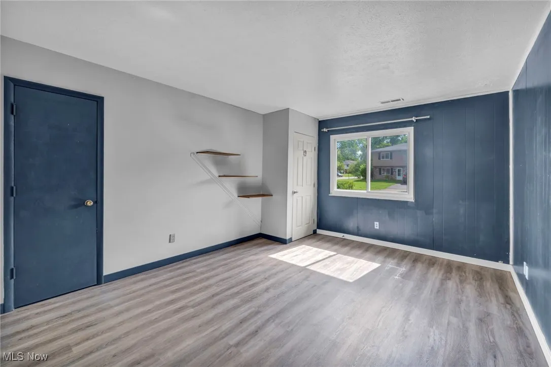 Bedroom with dark wood-type flooring and baseboards
