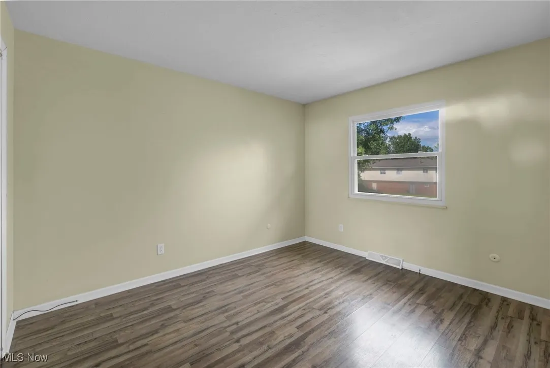 Bedroom featuring wood finished floors and baseboards