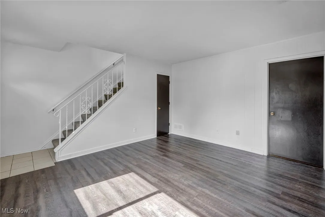 Additional first floor living space, featuring dark wood-type flooring, closet and laundry access