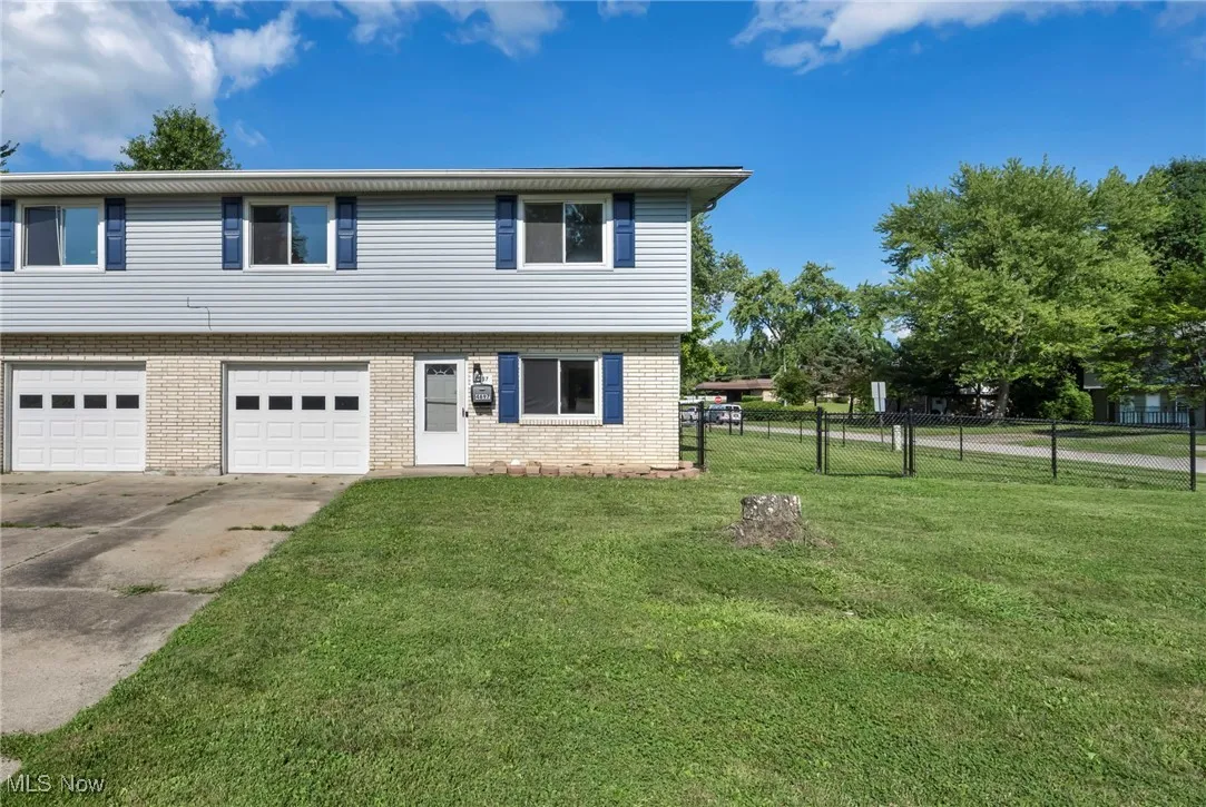 View of 4697 side of Colonial Duplex featuring concrete driveway, an attached garage, and brick siding