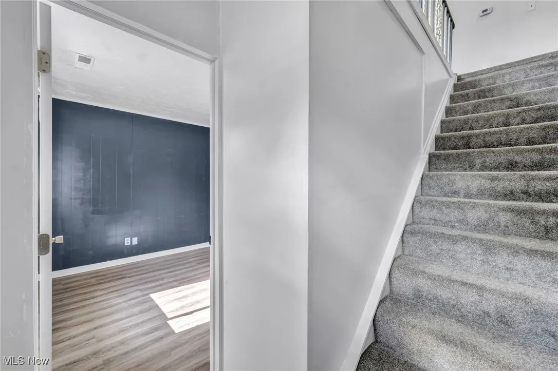 Entry staircase with baseboards and wood finished floors