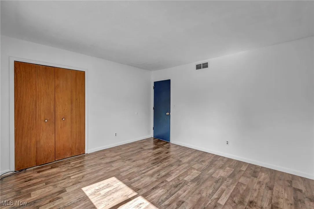 Bedroom with dark wood-type flooring and baseboards