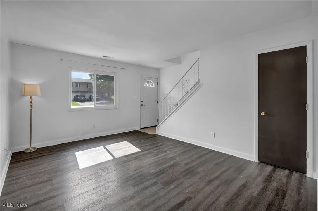 Additional first floor living space, featuring dark wood-type flooring, closet and laundry access