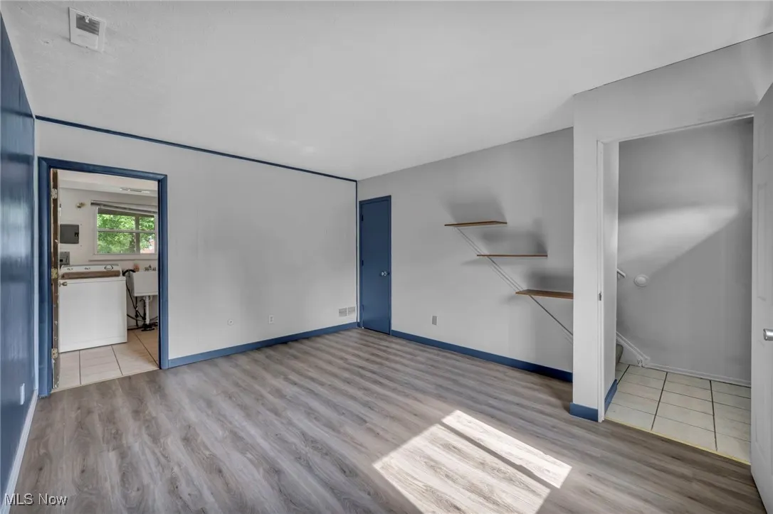 Bedroom with dark wood-type flooring and baseboards