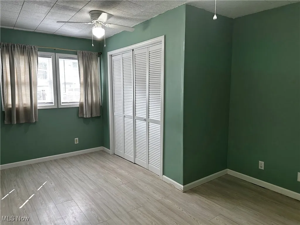 Primary bedroom with cloest and ceiling fan