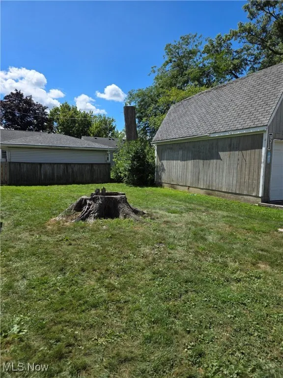 View of yard featuring a detached garage and an outdoor structure