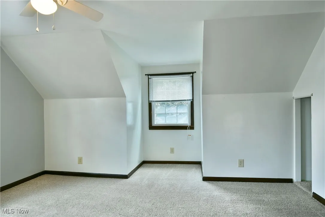 Bonus room featuring light colored carpet and lofted ceiling