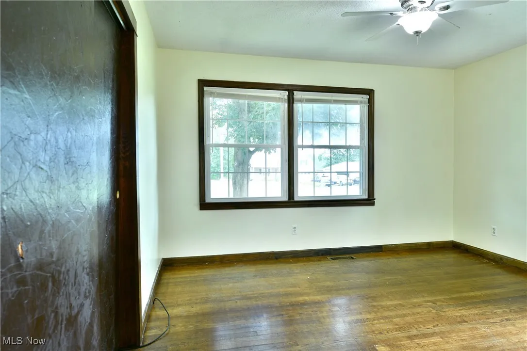 Unfurnished room featuring wood finished floors and a ceiling fan