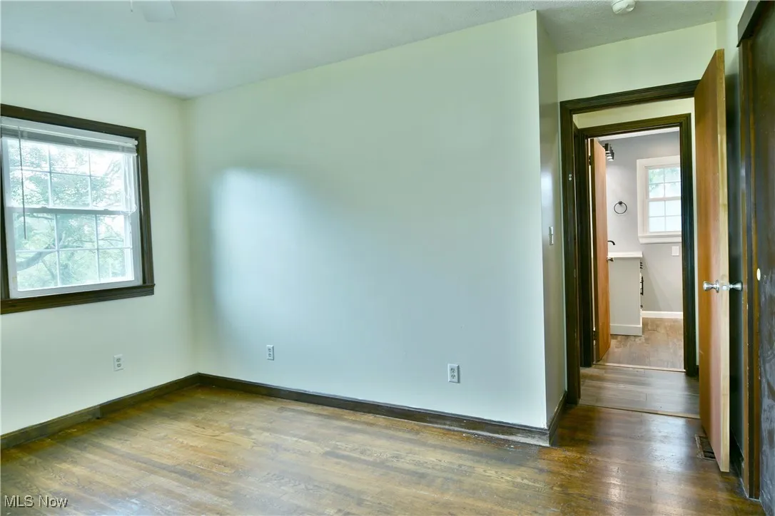 Unfurnished room with wood finished floors and baseboards