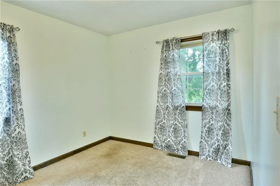 Empty room with carpet flooring and baseboards