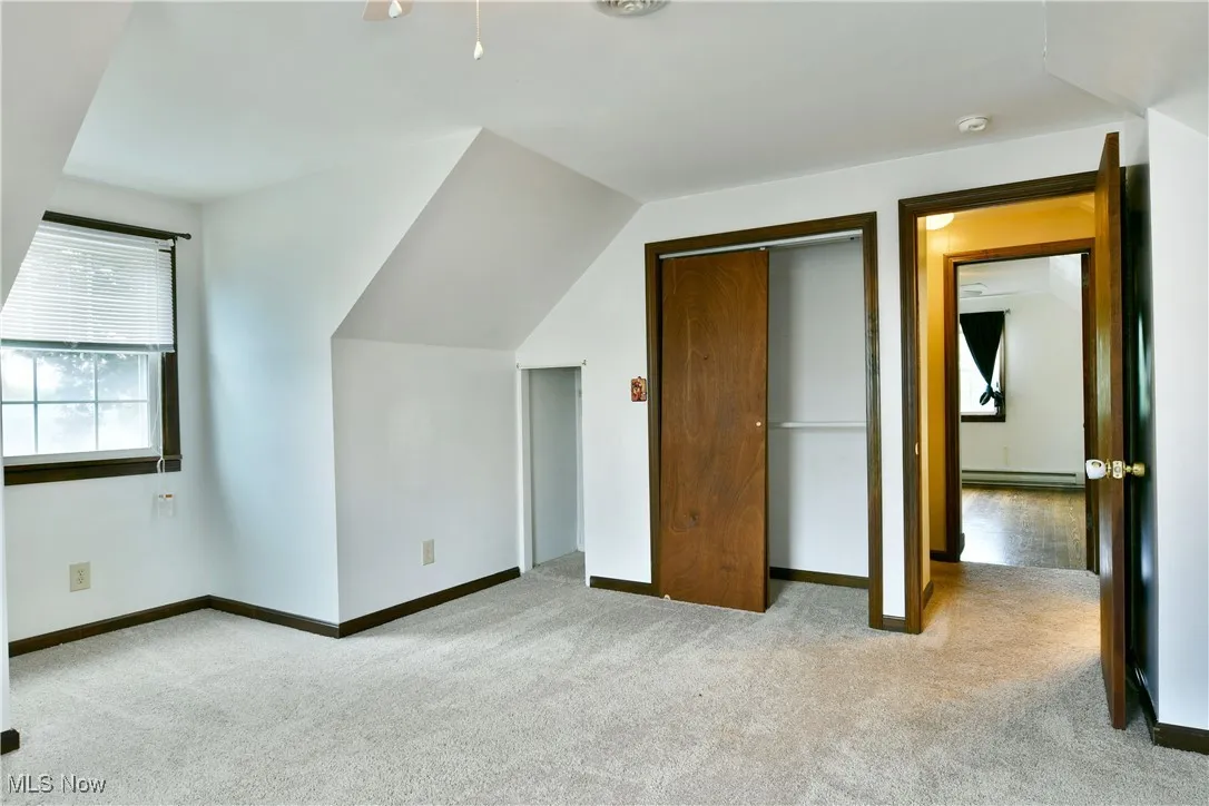 Bonus room featuring light carpet, lofted ceiling, and baseboard heating