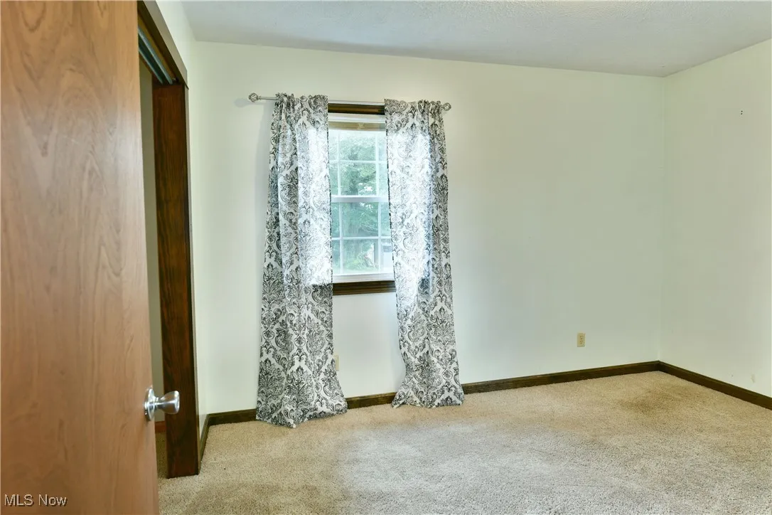 Empty room with carpet and baseboards