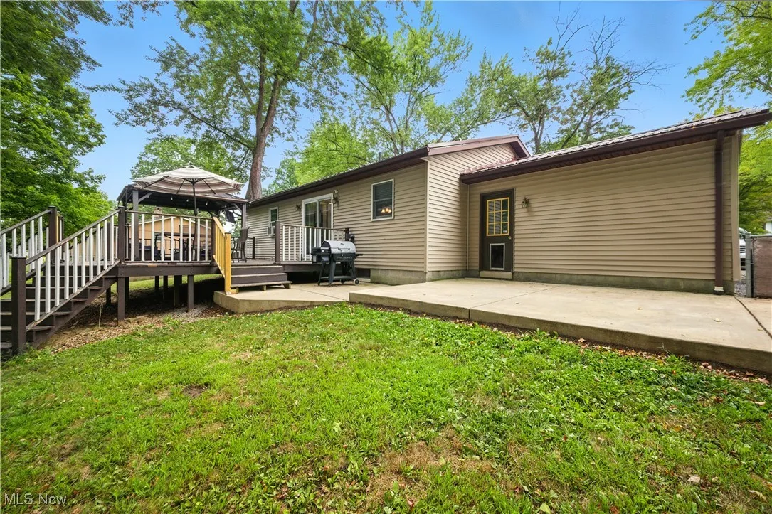 Back of house with a gazebo, a patio area, a lawn, and stairway