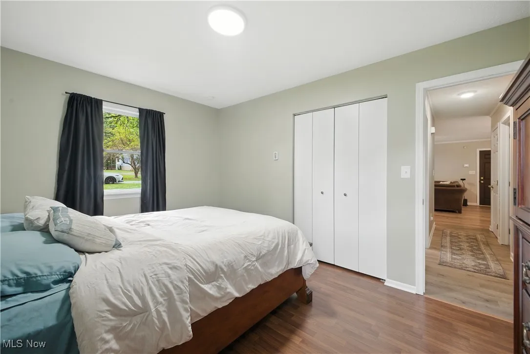 Bedroom with wood finished floors and a closet