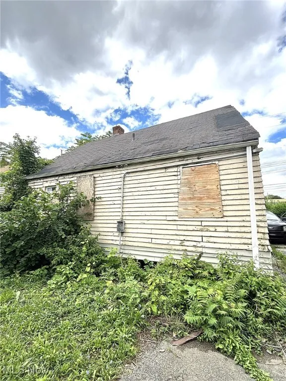 View of side of home featuring a chimney