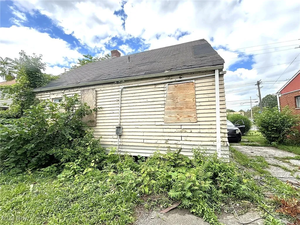 View of side of home featuring a chimney and roof with shingles