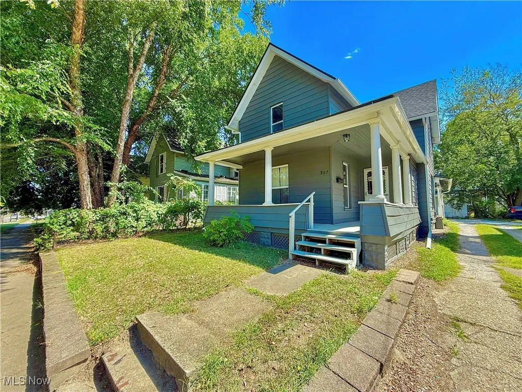 View of front of house with covered porch and a front lawn