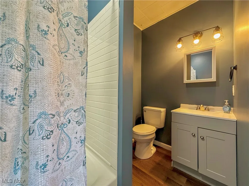 Full bathroom featuring vanity and dark style flooring
