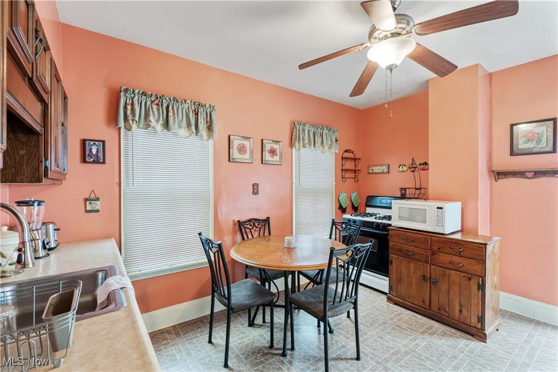 Dining area with a ceiling fan and light tile patterned flooring