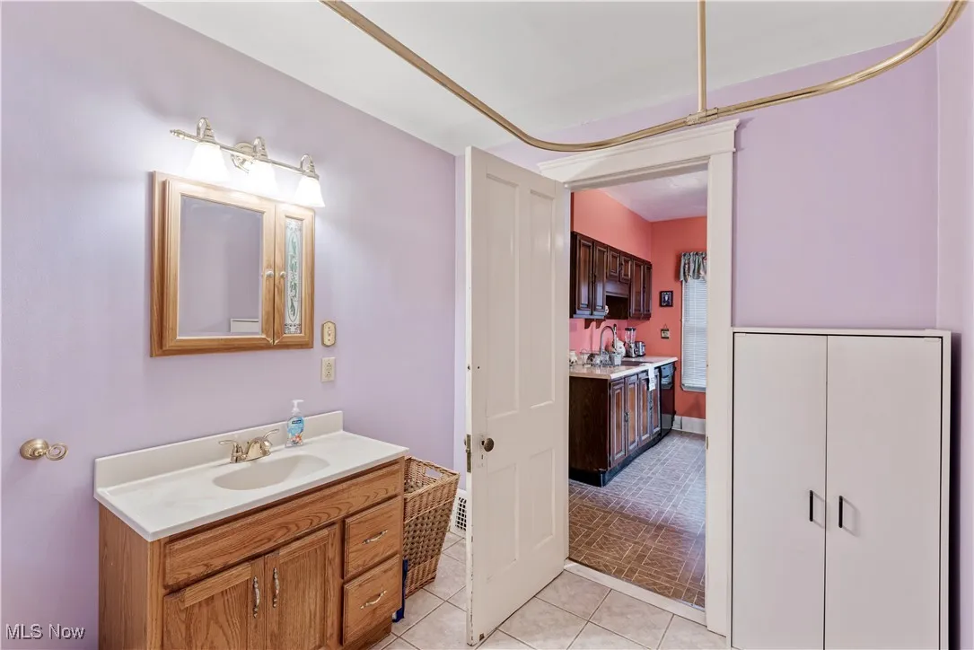 Full bath featuring vanity and light tile patterned floors