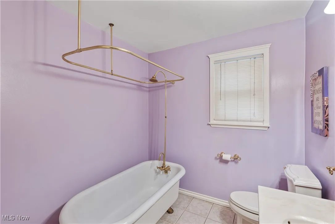 Full bath featuring light tile patterned floors, a combined bath / shower with freestanding tub, and vanity