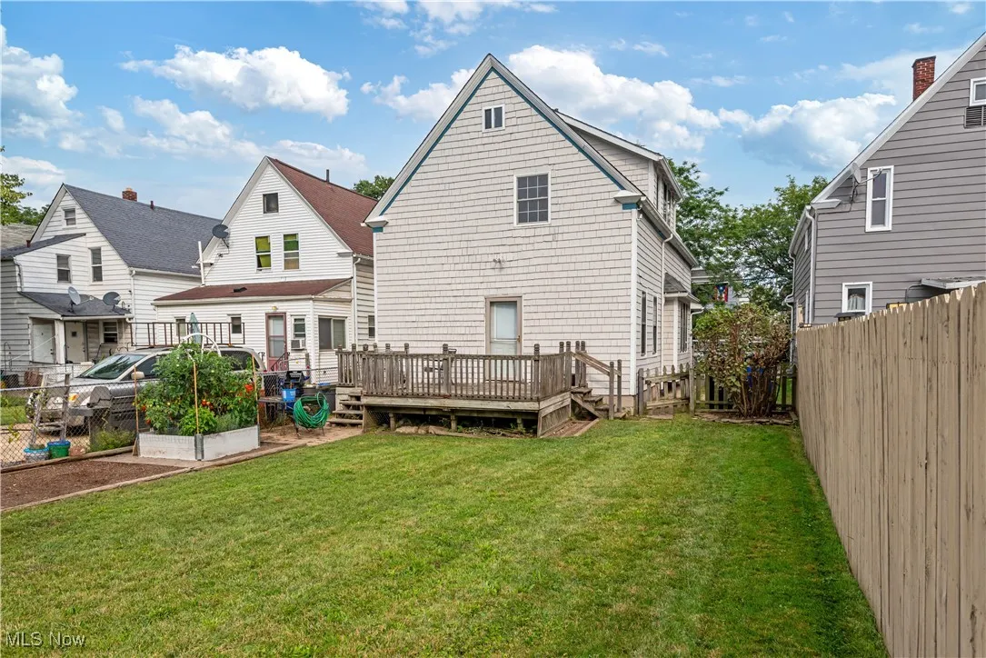 Back of property with a fenced backyard and a deck